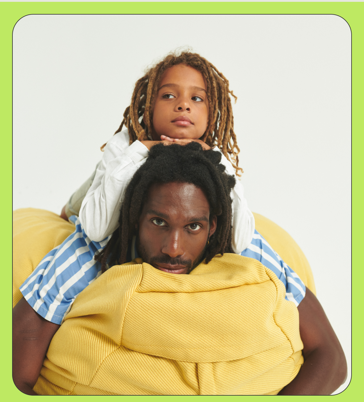 A father and son laying on a bright yellow squishy chair