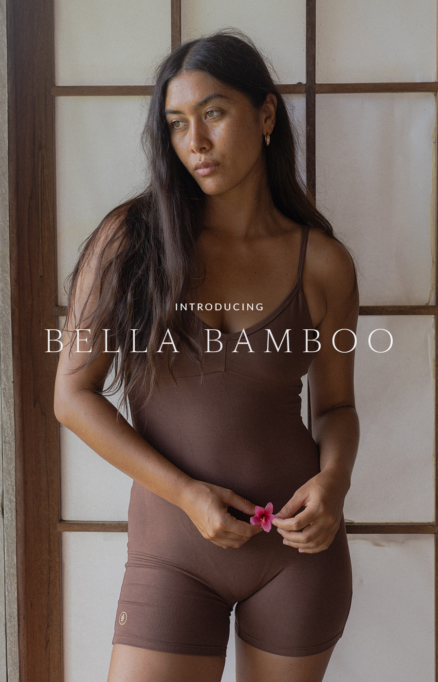 Woman in a brown unitard holding a pink flower, with text overlay reading “Introducing Bella Bamboo.”
