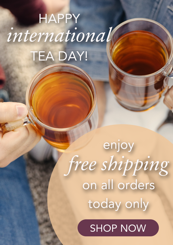 Photo of two glass mugs full of tea being held close together by two people who are sitting on a blanket. The overlay text reads: "Happy International Tea Day! Enjoy free shipping today only. SHOP NOW."